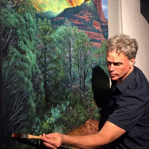 James Havens painting a red rock landscape on a large canvas